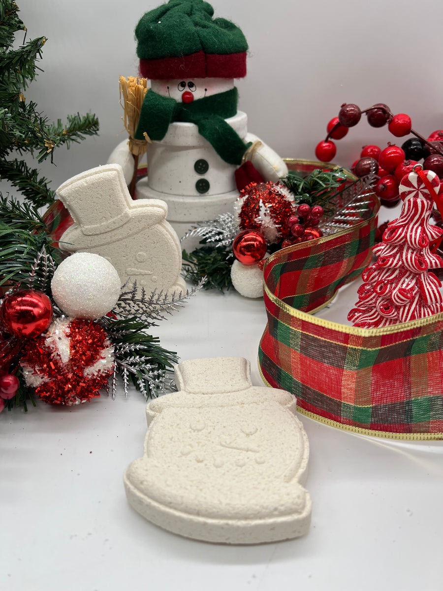 all natural christmas themed bath bombs shaped like snowmen resting on a christmas themed background