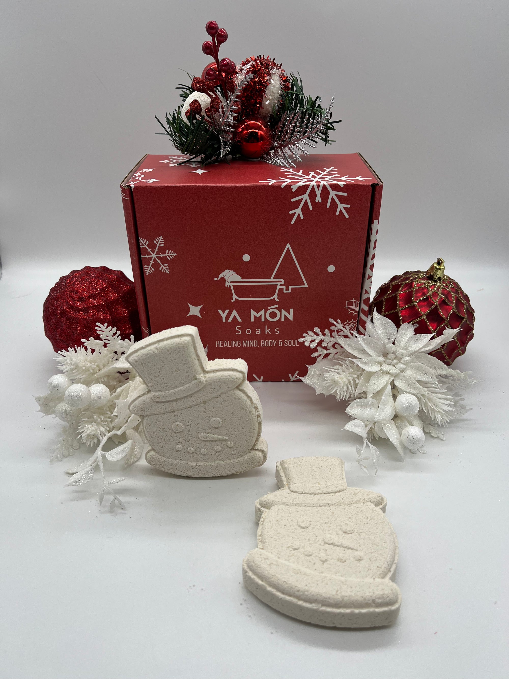 all natural christmas themed bath bombs shaped like snowmen resting on a christmas themed background