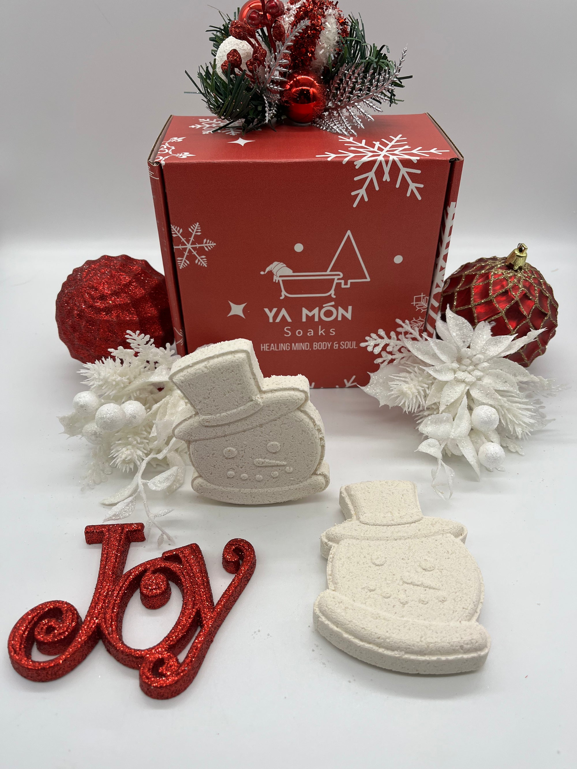 all natural christmas themed bath bombs shaped like snowmen resting on a christmas themed background